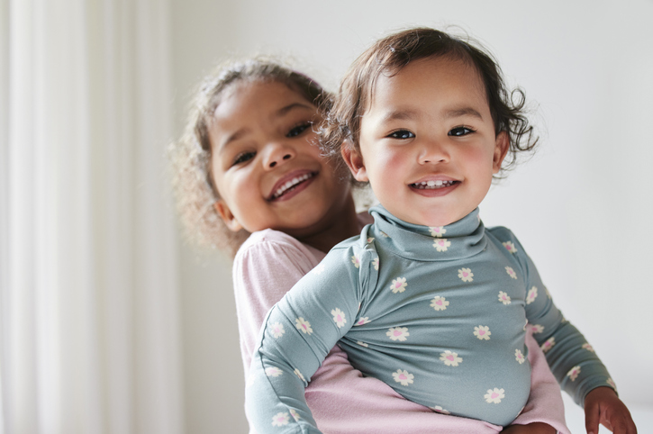 Two little sisters spending time together at home